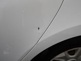 a white car with a hole in the side of it