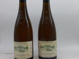 deux bouteilles de vin posées l'une à côté de l'autre sur une surface blanche