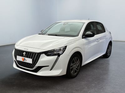 La voiture blanche est garée dans une grande pièce au sol noir.