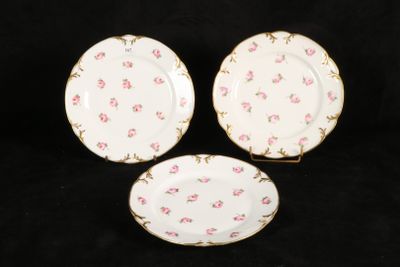 three plates with pink flowers on them on a black background