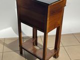 a small wooden table with a black top on a tiled floor