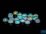 un tas de perles d'oplite blanches sur une surface noire