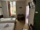 une chambre avec deux lits, une télévision et un fauteuil