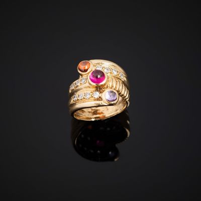 a close up of a gold ring with pink and orange stones