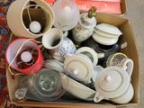 a box full of tea cups and saucers on the floor