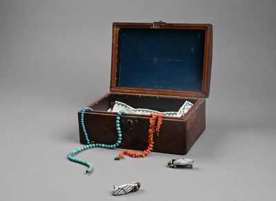 une petite boîte en bois contenant des perles et un collier