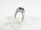 a close up of a diamond and sapphire ring on a white surface