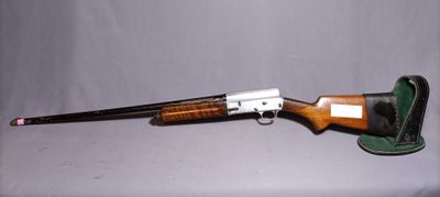 the rifle is sitting on the table next to the hat