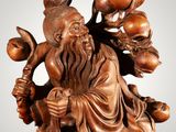an image of a wooden statue of a man holding a pot