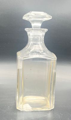 a clear glass bottle with a small amount of liquid in it