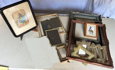 a lot of framed pictures on a table next to a picture