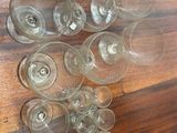 many empty wine glasses sitting on a wooden table