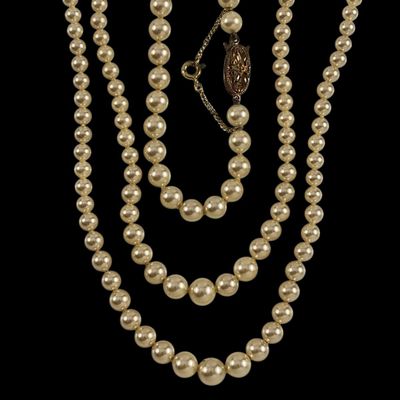 un gros plan d'un collier de perles sur fond noir