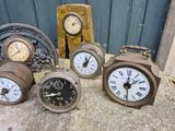 four different clocks sitting on a table next to each other