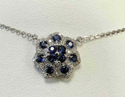 blue and white diamond flower pendant on a silver chain