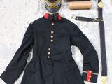 un manteau noir et une paire de chaussures blanches par terre