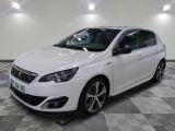 la voiture blanche est garée sur un sol en damier dans le garage