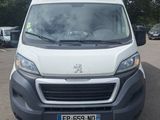une camionnette blanche garée sur un parking près des arbres