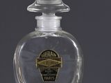 a bottle of perfume and a box of oranges on a table