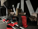 a stage set up with chairs, chairs, and red carpet