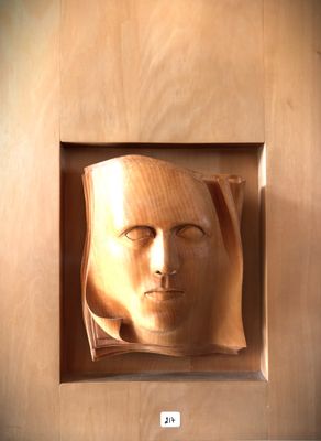a picture of a wooden sculpture of a man ' s face
