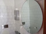 a bathroom with a toilet, sink and mirror in it