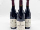 trois bouteilles de vin rouge sont alignées sur une surface blanche