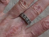 a woman ' s hand with a diamond ring on it