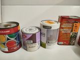 several cans of paint are lined up on a counter top