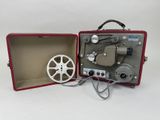 un vieux projecteur de cinéma rangé dans un coffret rouge