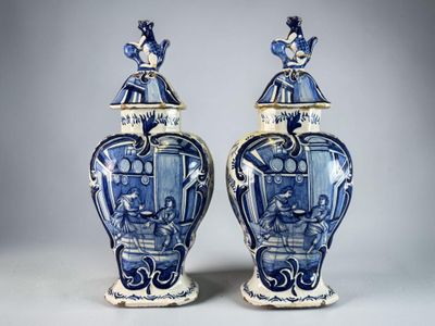 pair of blue and white vases with figures on them