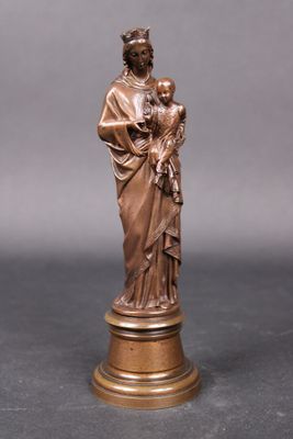 une statue en bronze représentant une femme tenant un enfant dans ses bras, posée sur un socle