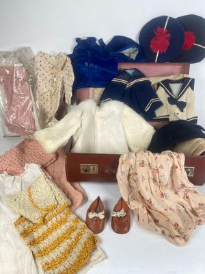 une valise remplie de vêtements et de chaussures posée sur une surface blanche