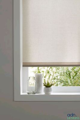 a close up of a window with a white roller shade on it
