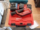 une boîte à outils rouge posée sur une table, avec des outils dessus