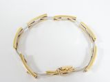 a close up of a gold and silver bracelet on a white surface