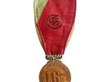 une ancienne médaille avec un ruban rouge sur fond blanc