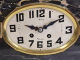 two clocks that are sitting on a marble table