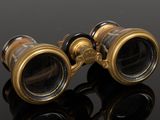 an antique pair of binoculars sitting on top of a black surface