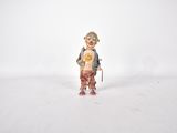 une figurine représentant un clown tenant un ours en peluche