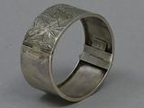 a close up of a silver bracelet with a cross on it