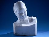 a small white statue of a child on a blue surface