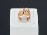 une photo d'une bague en or sertie de deux diamants, posée sur une boîte blanche