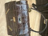 two black purses on a wooden floor next to each other