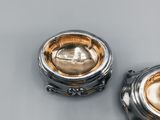 pair of silver and gold plated teapots on a grey surface