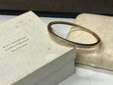 a gold bracelet with diamonds on it sitting in a box