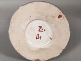 a white plate with red writing on it on a table