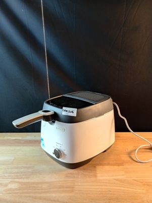 un grille-pain posé sur une table, avec un cordon d'alimentation qui y est branché