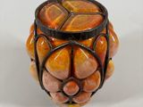 a small vase with a design on it on a white surface