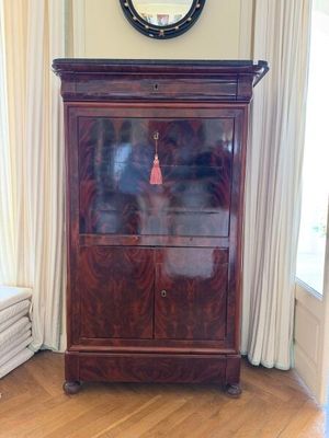 une armoire en bois dans un coin de la pièce, avec une horloge accrochée au mur